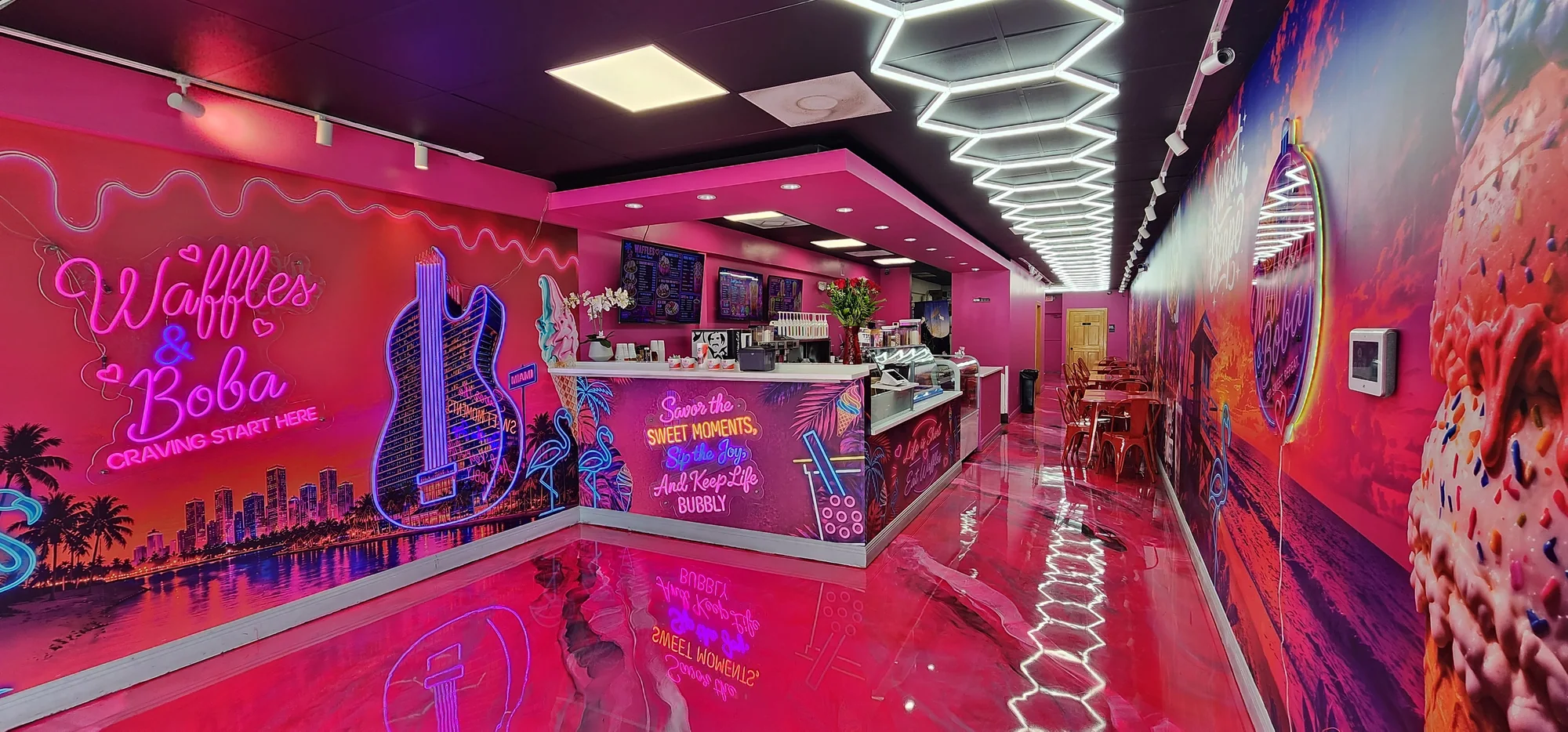 Vibrant pink and neon interior of Waffles & Boba